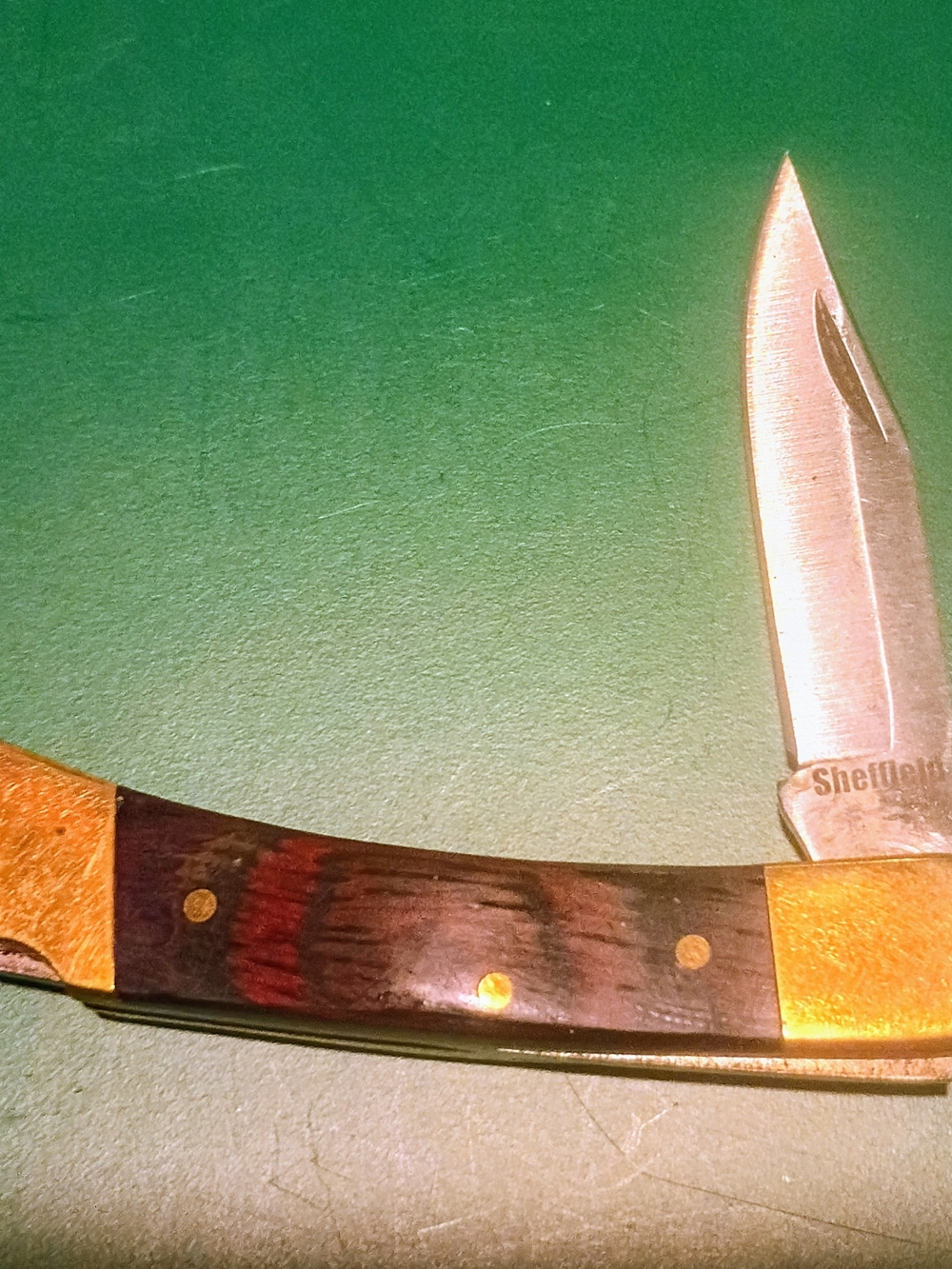 Sheffield lockback folding pocket knife with a wood handle and brass bolsters.